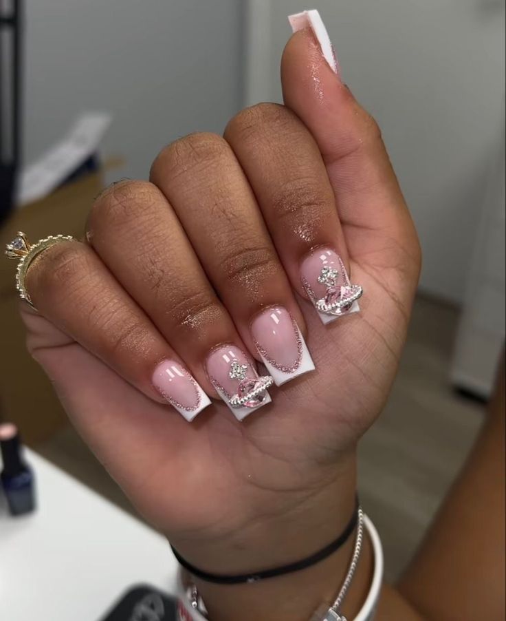 Sophisticated Soft Pink French Tip Nail Design with Glamorous Silver Accents and Sparkling Gems.