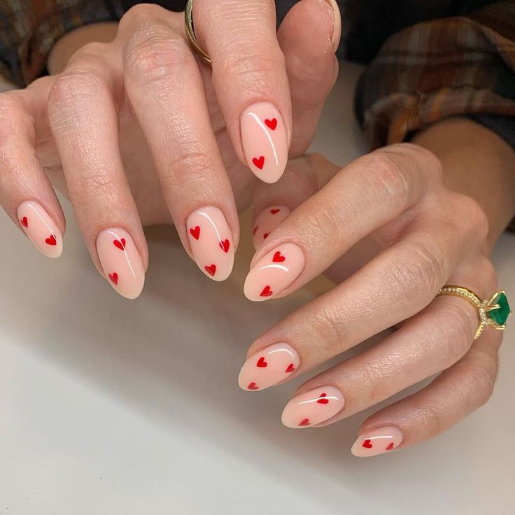 Playful Chic: Heart-Patterned Nail Design with Vibrant Red Hearts on Nude Base.