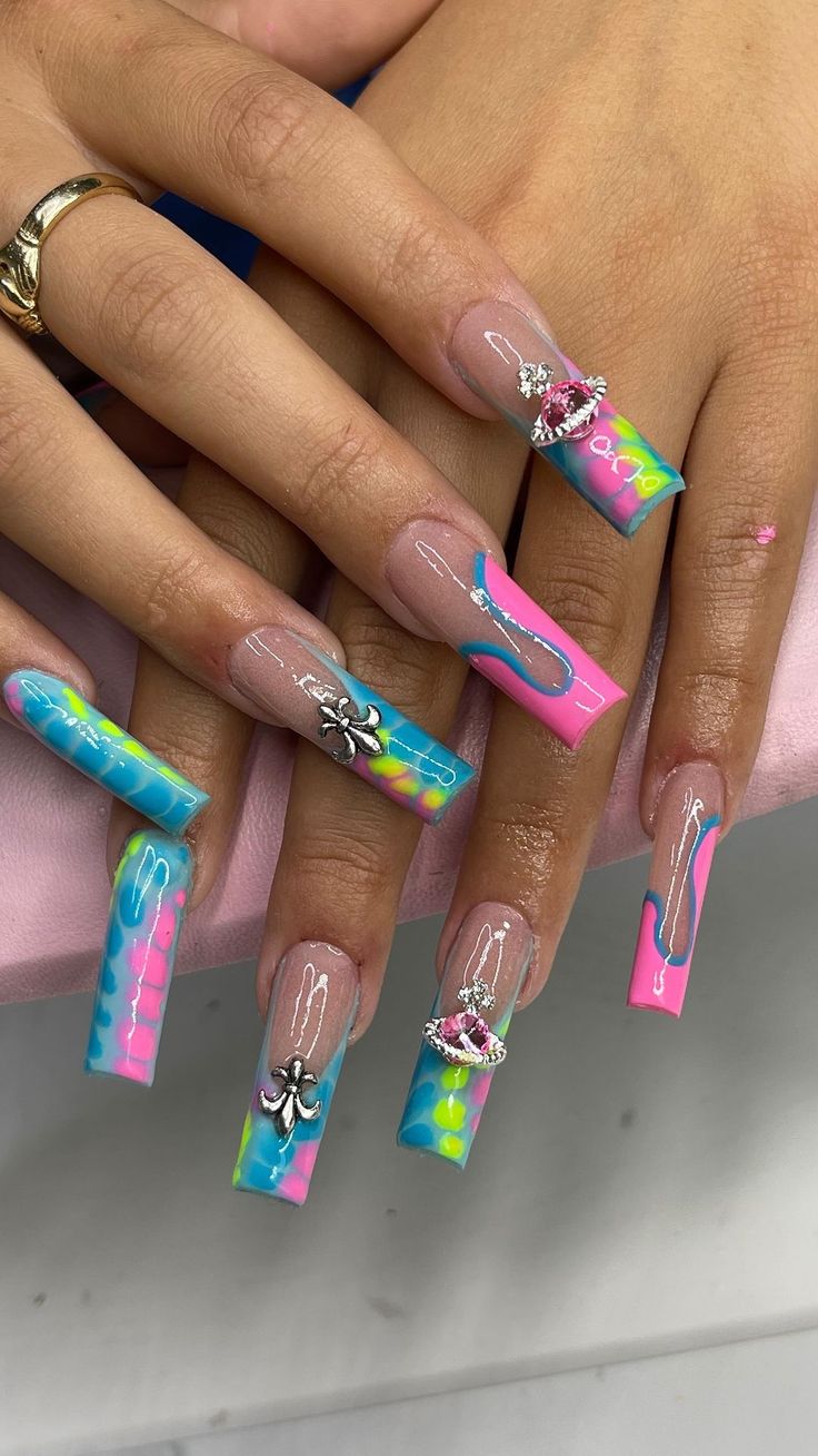 Playful Vibrant Nail Design: Long Acrylic Extensions with Charms and Intricate Linework in Blue, Pink, and Yellow.