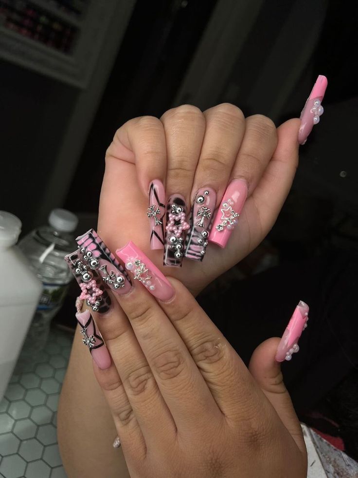 Glamorous Long Nail Design with Pink, Black, and Glossy Finishes Enhanced by Floral and Star Accents.