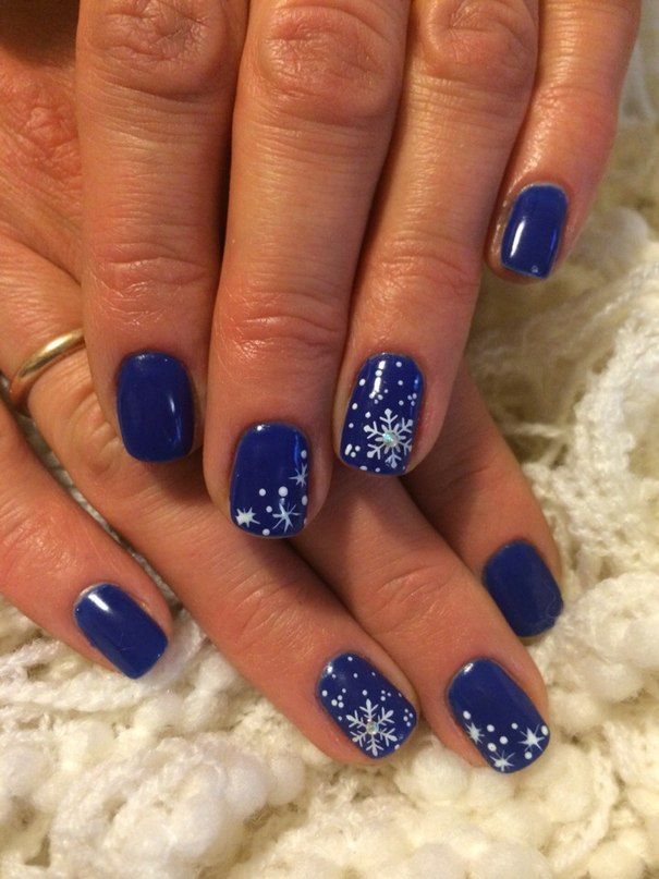 Elegant Deep Blue Nail Design with Whimsical White Snowflakes for Winter.