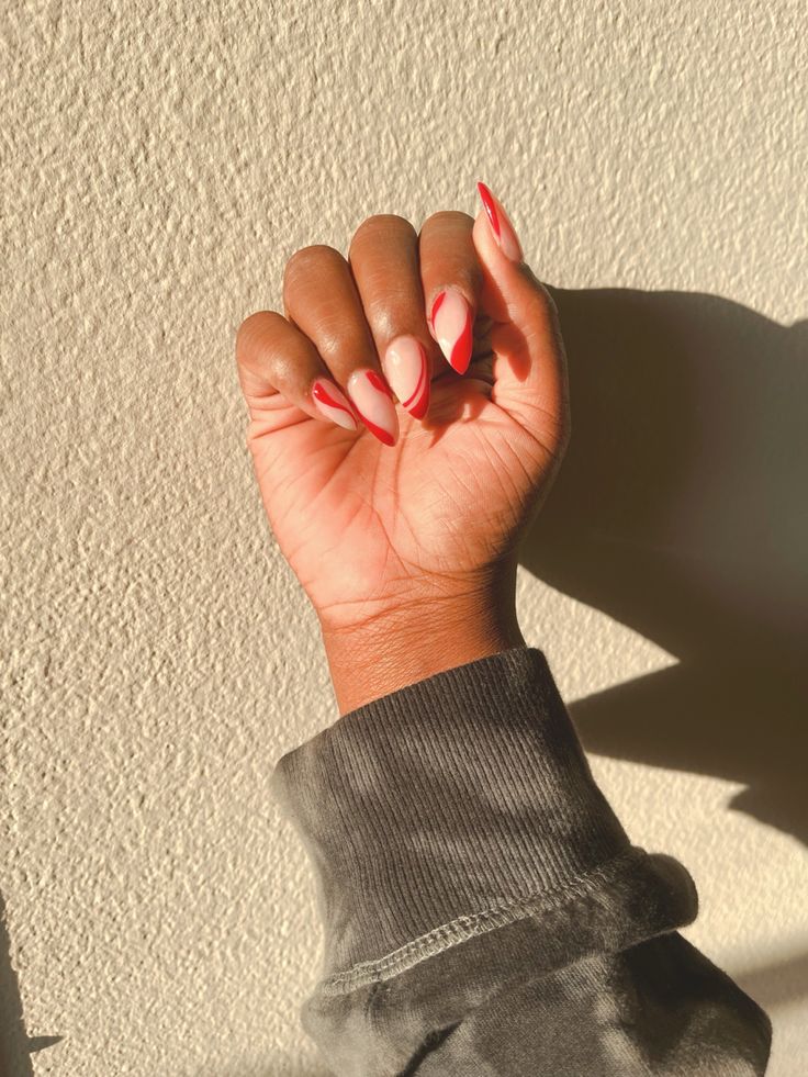 Sophisticated Nail Design: Soft Nude and Vibrant Red with Delicate Outlines.