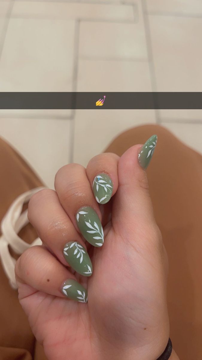 Elegant Green Nail Design with Leaf Pattern and Almond-Shaped Tips.