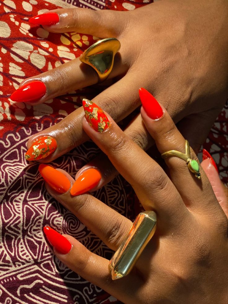 Luxurious Red and Orange Vivid Nail Design with Gold Leaf Accents.