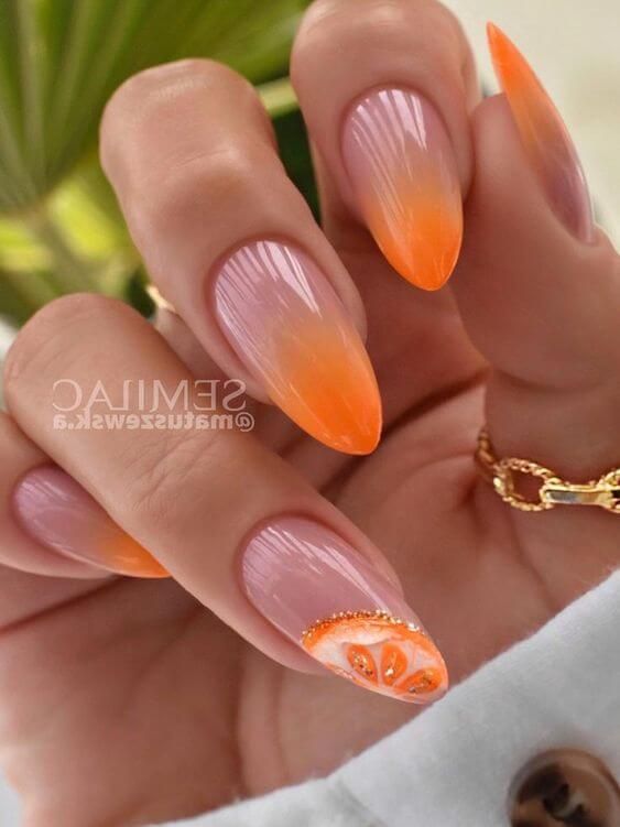 Eye-Catching Vibrant Orange Ombre Nails with Playful Fruit Art and Elegant Gold Detailing.