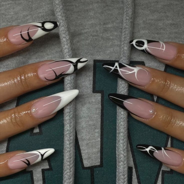 Sophisticated Almond Nail Art: A Stylish Blend of Soft Pink and Bold Black and White Designs.