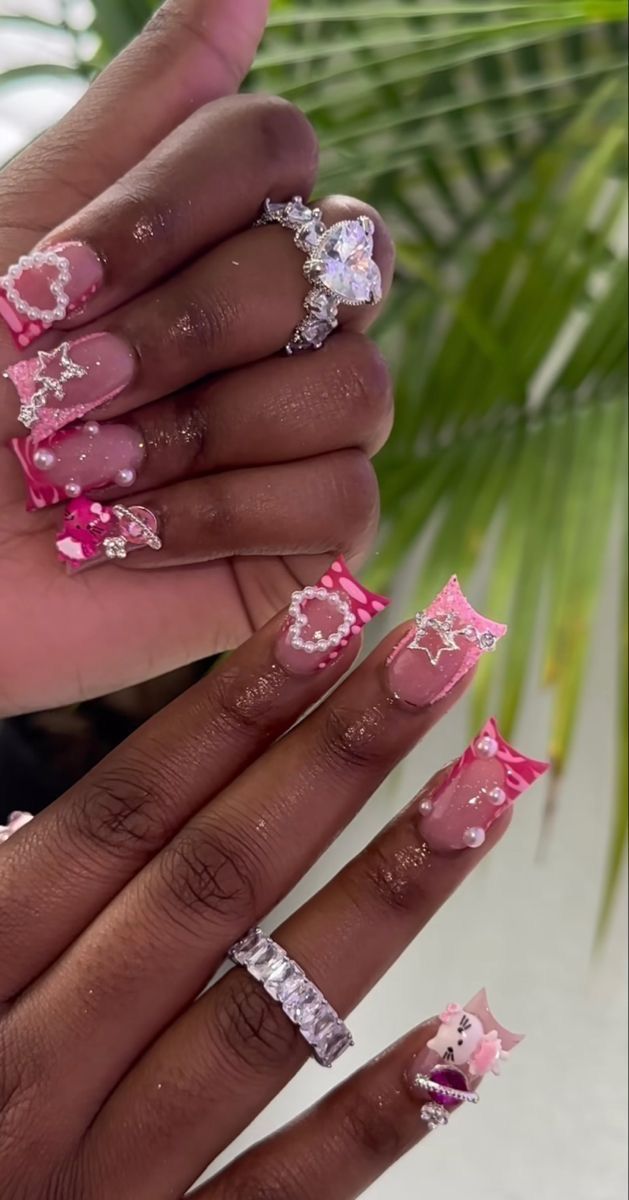 Glamorous Pink Nail Design with Glossy and Matte Finishes, Embellished with Stars, Pearls, and Rhinestones.