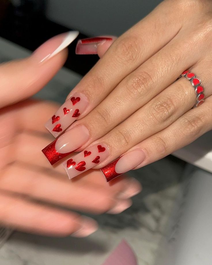 Chic Nude and Glittery Red Nail Design with Romantic Heart Accents