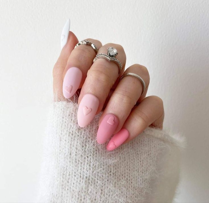 Playful Matte Pastel Pink Nail Design with Heart Motifs and Chic Accents.