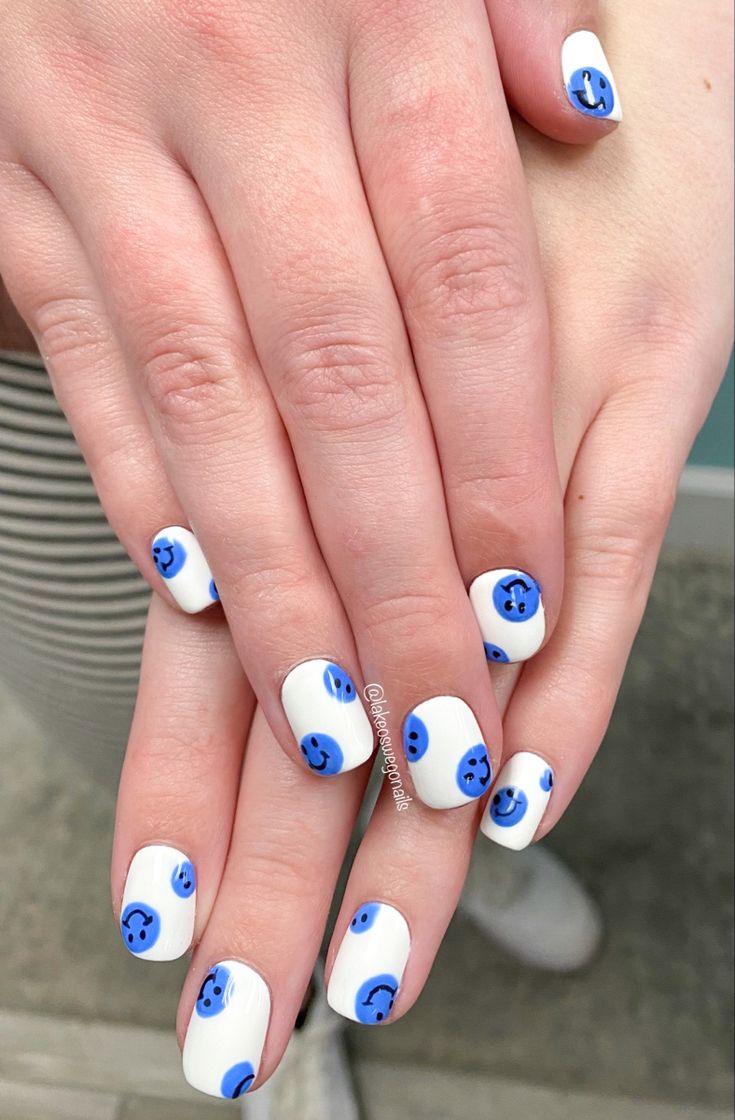 Playful Blue Smiley Face Nail Design on Crisp White Background