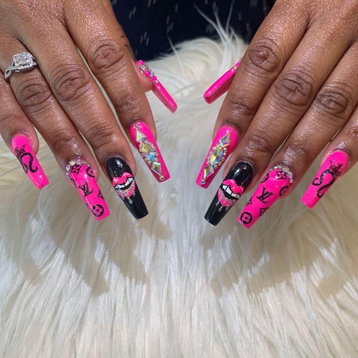 Bold Vibrant Pink and Black Stiletto Nail Design with Playful Elements and Glossy Finishes.