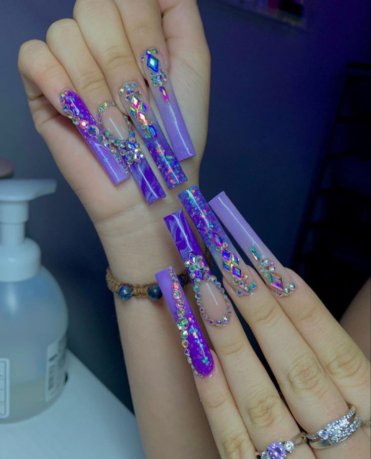 Bold Purple Acrylic Nails Adorned with Shimmering Rhinestones for a Luxurious Aesthetic.