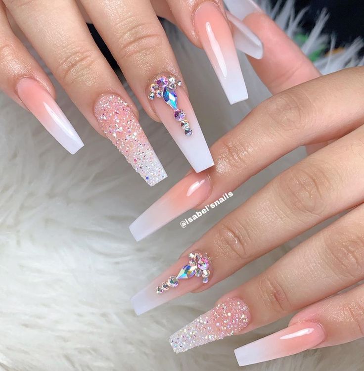 Elegant Elongated Acrylic Nail Design with Soft Pink and White, Sparkling Glitter Gradients, and Luxurious Gemstones.