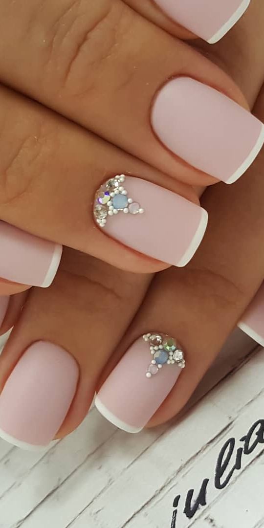 Whimsical Soft Pink Matte French Tip Nail Design with Sparkling Rhinestone Accents.