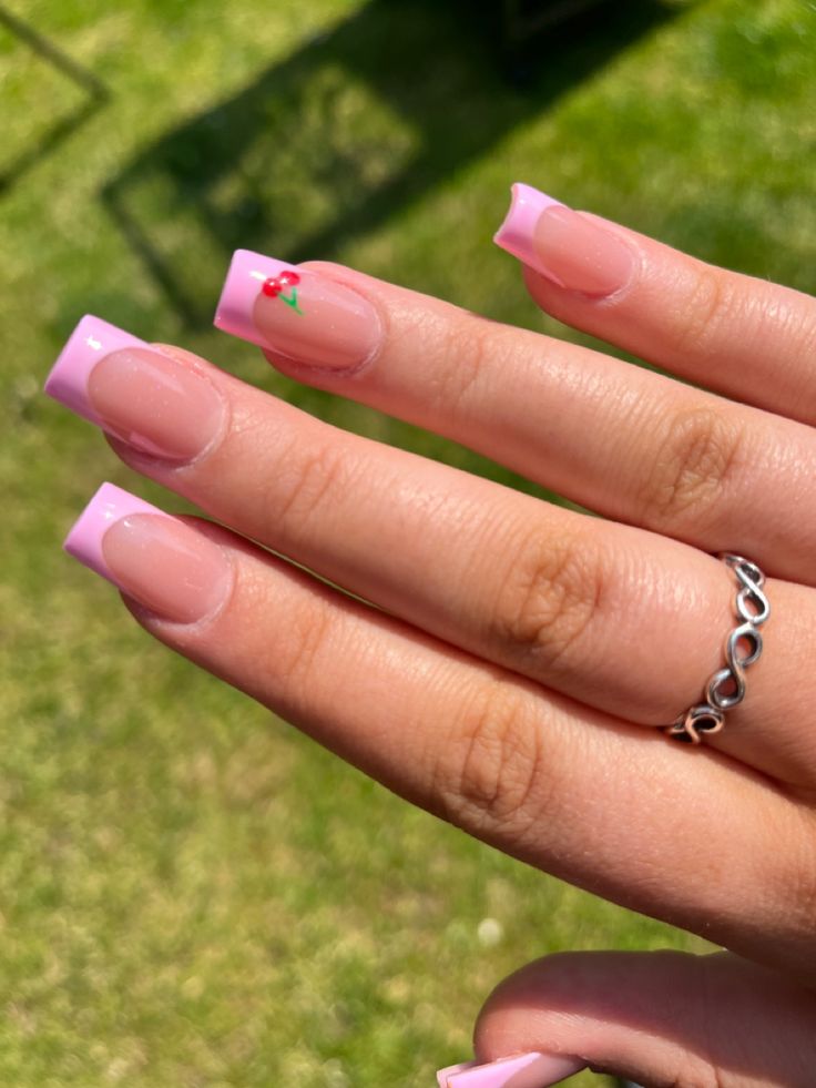 Chic Soft Pink French Tip Nails with Playful Cherry Accent for a Sunny Day.