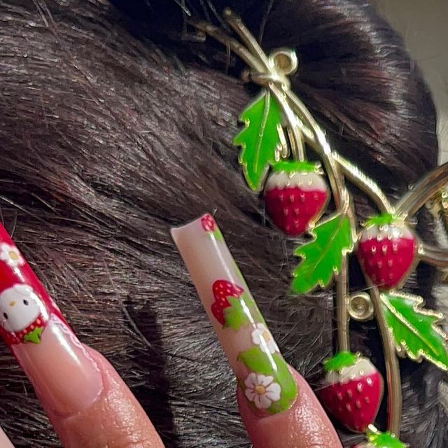 Playful Strawberry-Themed Nail Art: Vibrant Acrylics and Matching Accessories for a Lively Summer Look.