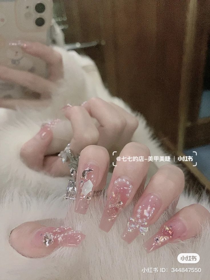 Elegant Long Clear Acrylic Nails Adorned with Sparkling Flakes and Gems for Special Occasions.