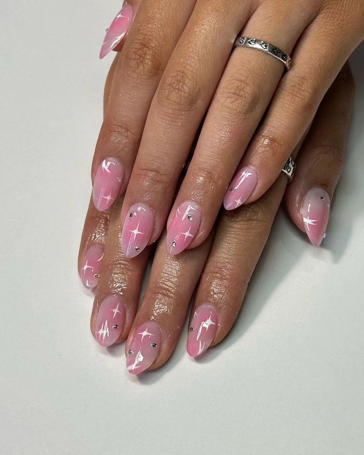 Chic Soft Pink Gradient Nails with Starburst Patterns for a Playful Look.