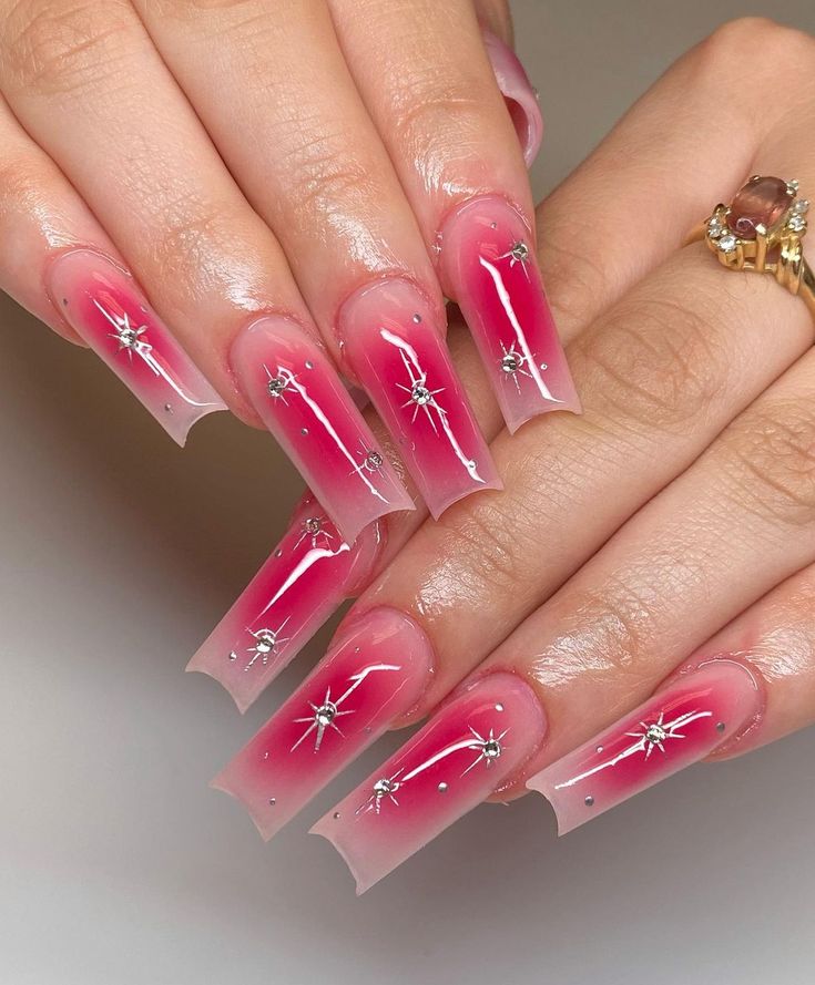 Playful Elegance: Vibrant Pink to Soft Nude Ombre Nails with Silver Star Accents.