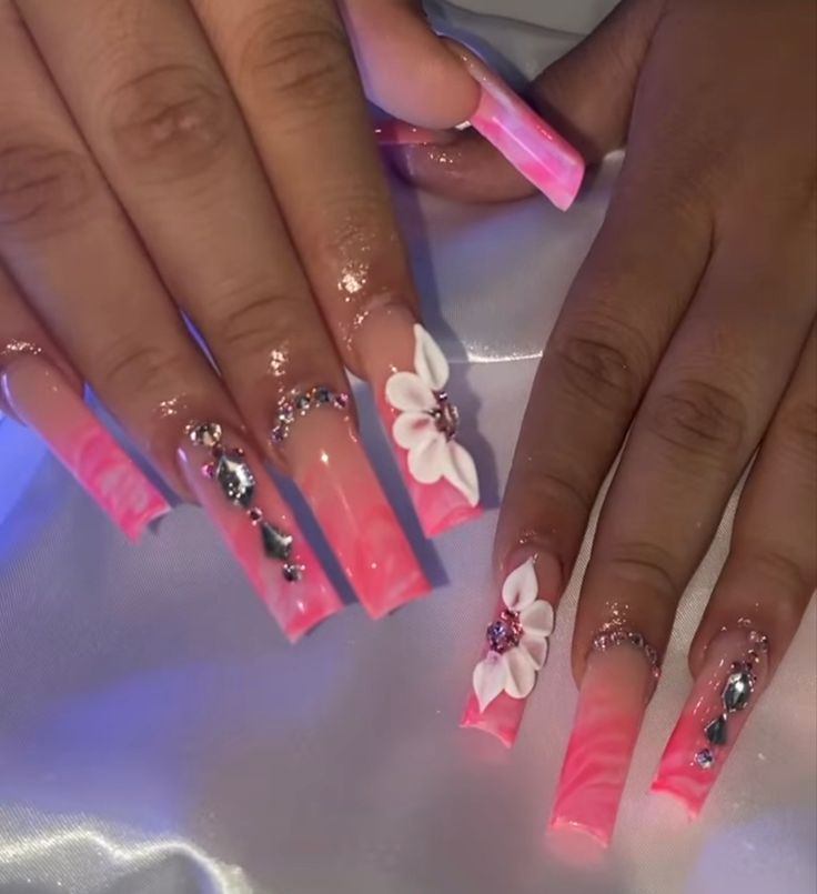 Elegant Gradient Pink Nail Design with Floral and Rhinestone Accents.