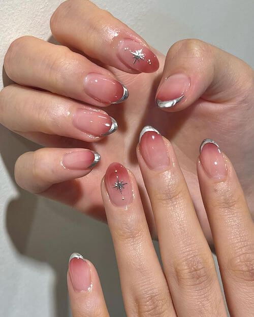 Elegant Nude Manicure with Subtle French Tips and Whimsical Star Accents