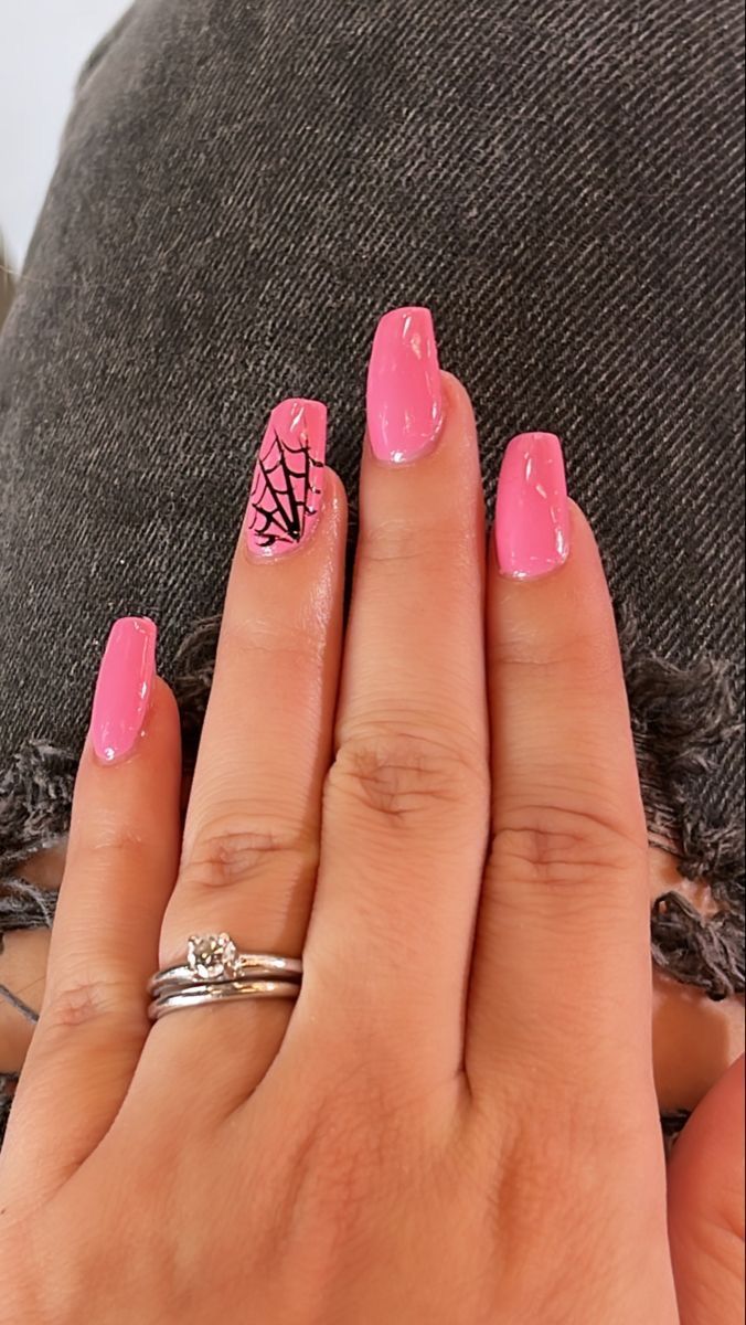 Whimsical Pink Nails with Glossy Finish and Spider Web Accent for a Playful Manicure.