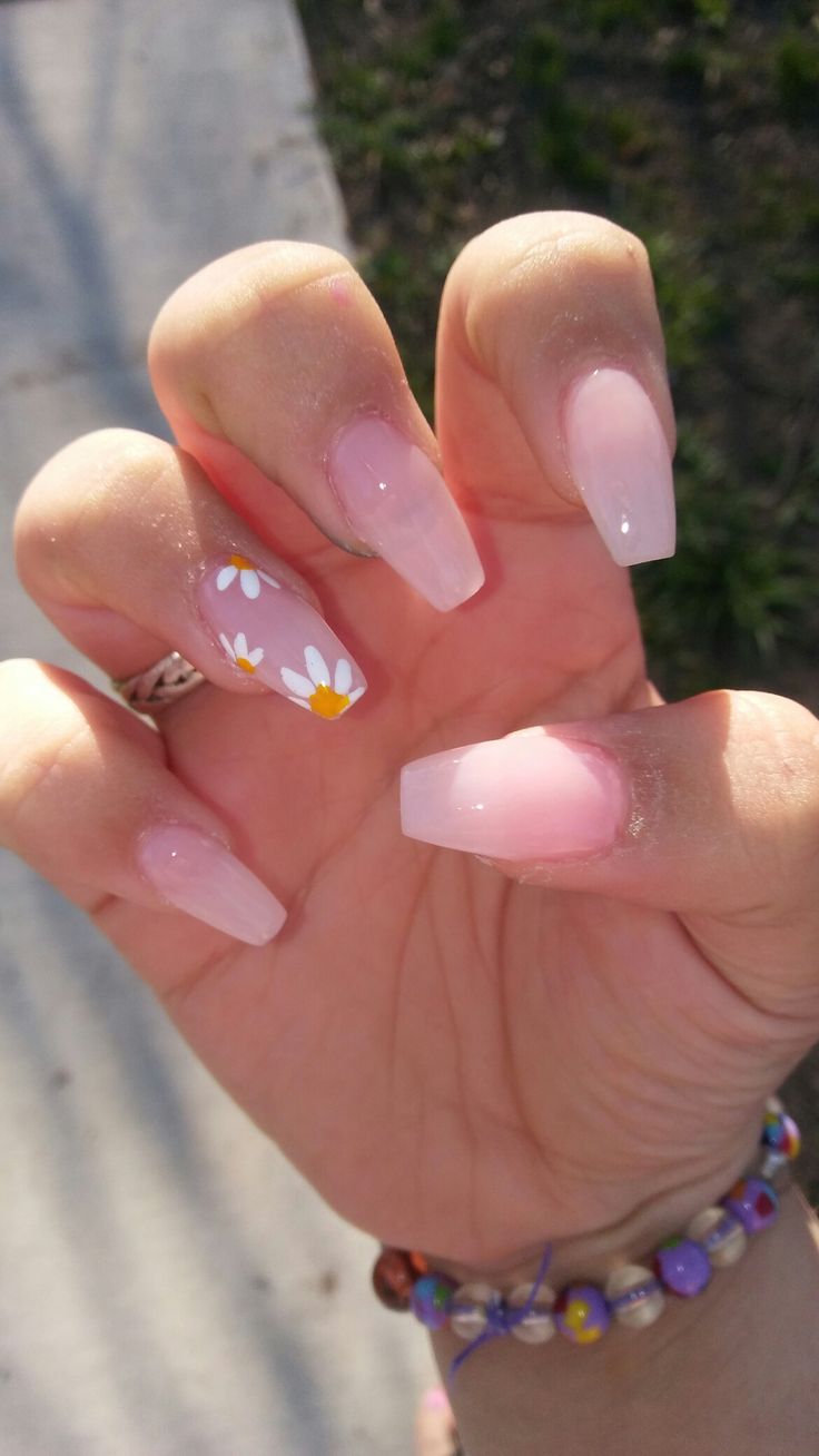 Chic Pink-Nude Ombre Nail Design Accented with Playful Daisy Flowers.