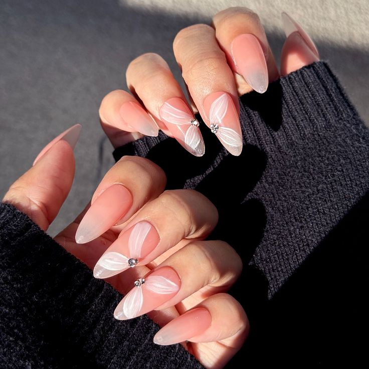 Sophisticated Almond-Shaped Nails with Soft Pink Gradients and Whimsical Floral Designs.