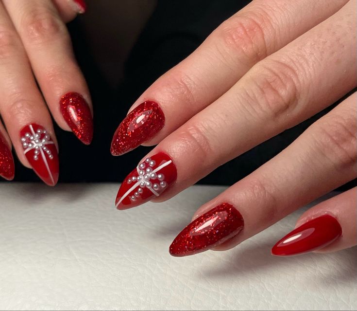 Sophisticated Elegant Red Nails with Glossy and Glitter Finishes, Intricate Gem Designs, and Almond Shape.