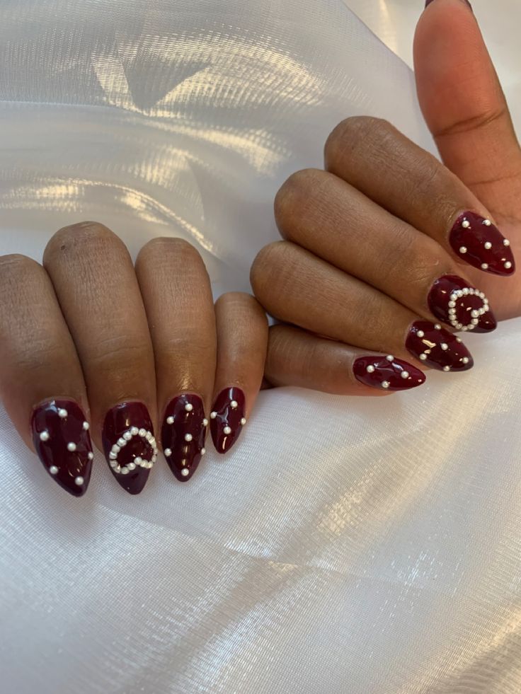 Sophisticated Nail Art: Deep Burgundy Base with Intricate White Designs