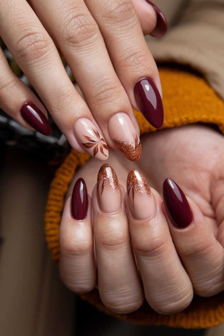 Sophisticated Nail Design: Deep Burgundy and Soft Nude with Floral Patterns and Glitter Accents.