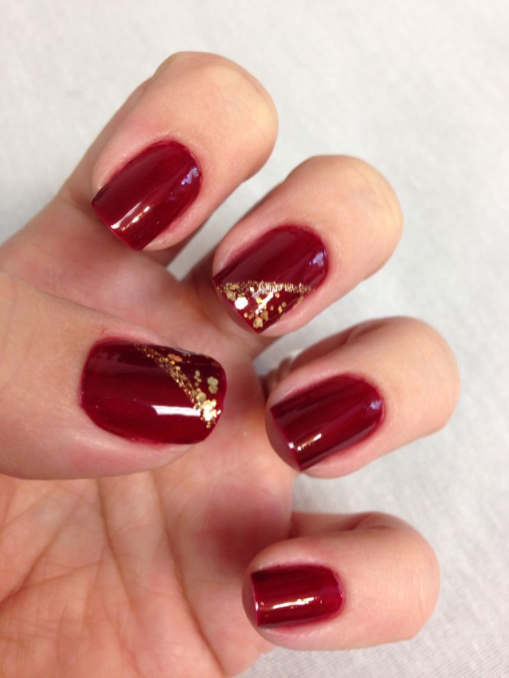 Sophisticated Burgundy Nail Design with Gold Accents and Sparkle.