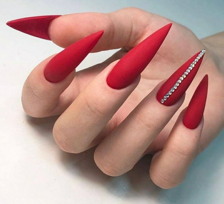 Bold Red Stiletto Nails: Elegance Meets Edgy Glamour with Rhinestone Accents.