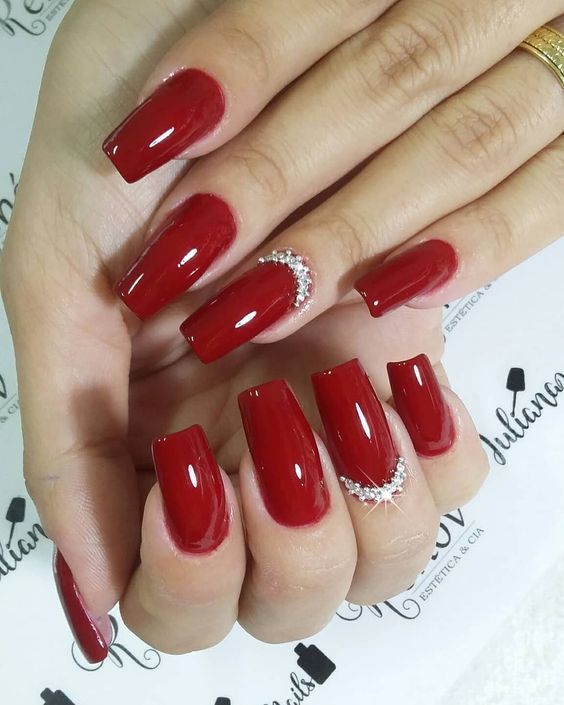 Elegantly Glamorous Red Nail Design with Glossy Finish and Rhinestones for Special Occasions