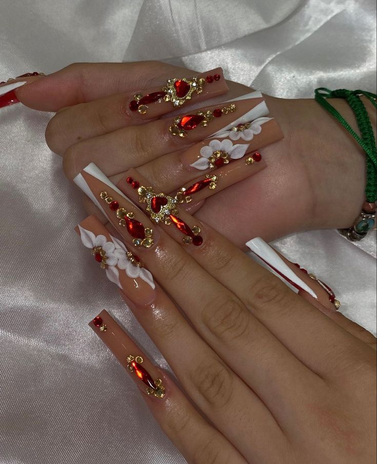 Luxurious Nail Art: Intricate Red Gemstones and Gold Accents on a Nude Base