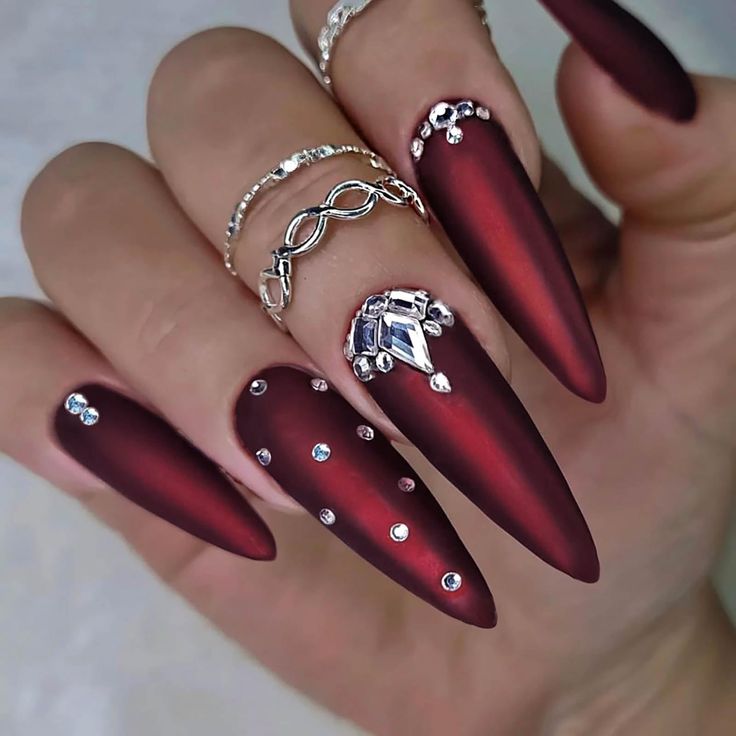 Chic Matte Burgundy Nails with Rhinestones and Elegant Accents.