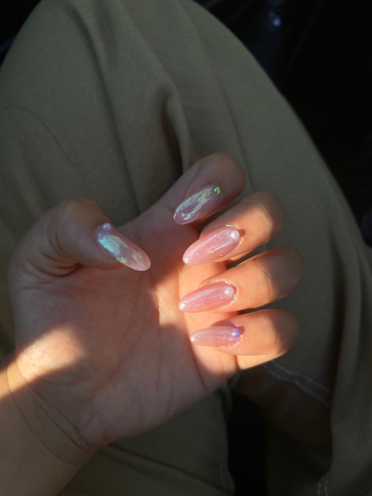 Sophisticated Soft Pink Nail Design with Iridescent Accents and Delicate Gem.