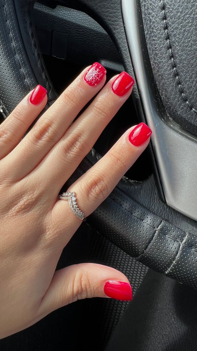 Bold Vibrant Red Winter Nail Design with Festive Snowflake and Elegant Ring Accent.