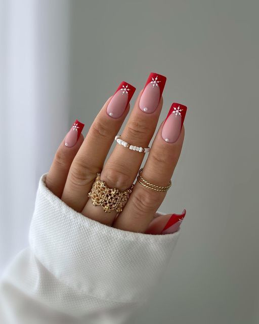 Chic Nail Design: Bold Red Tips with Soft Pink Base and Delicate White Accents.