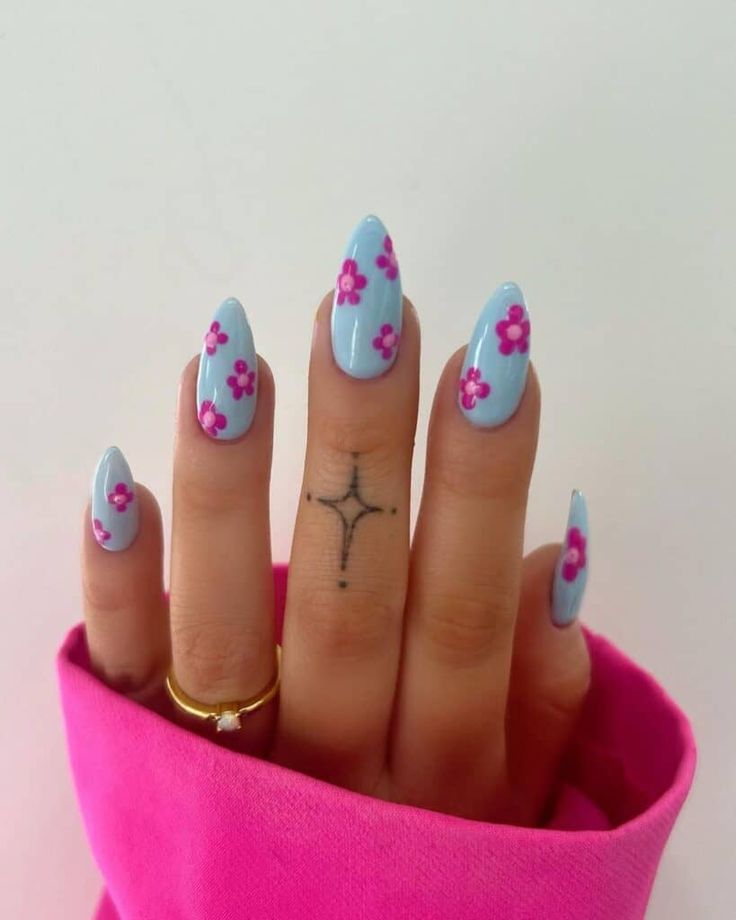 Chic Floral Nail Design with Soft Blue Base and Vibrant Pink Flowers for a Summery Look