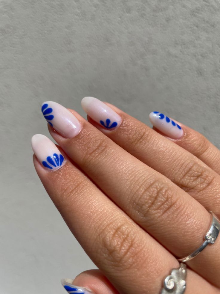 Chic Nail Design: Soft White and Vibrant Blue Hues with Floral Patterns