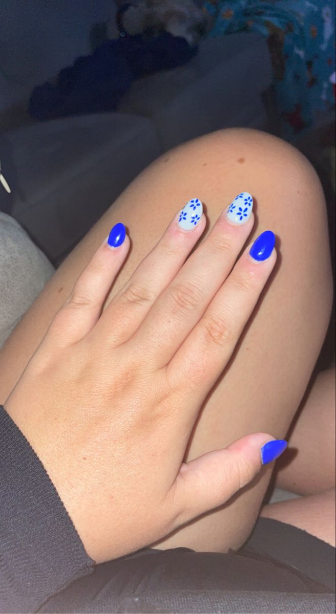 Playful Blue Floral Nail Design: A Cheerful Mix of Patterns for Any Occasion.