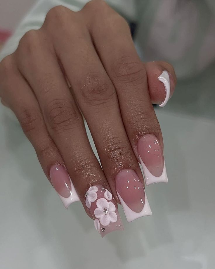 Chic Floral Nail Design with Soft Pink and White Colors and Unique Triangular Tips.