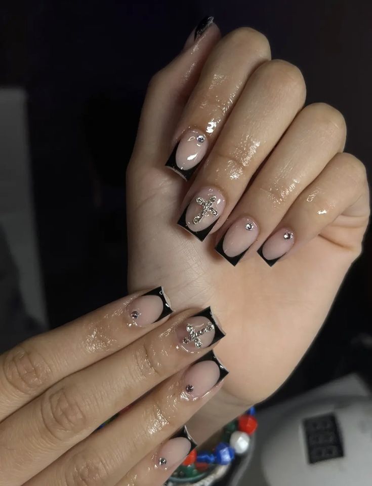 Sophisticated Nude and Black Nail Design with Intricate Gemstone Embellishments.