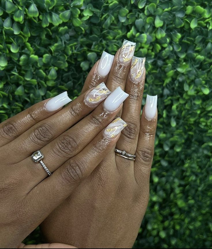 Chic Soft Nude Nail Design with Intricate Gold and White Marble Accents.