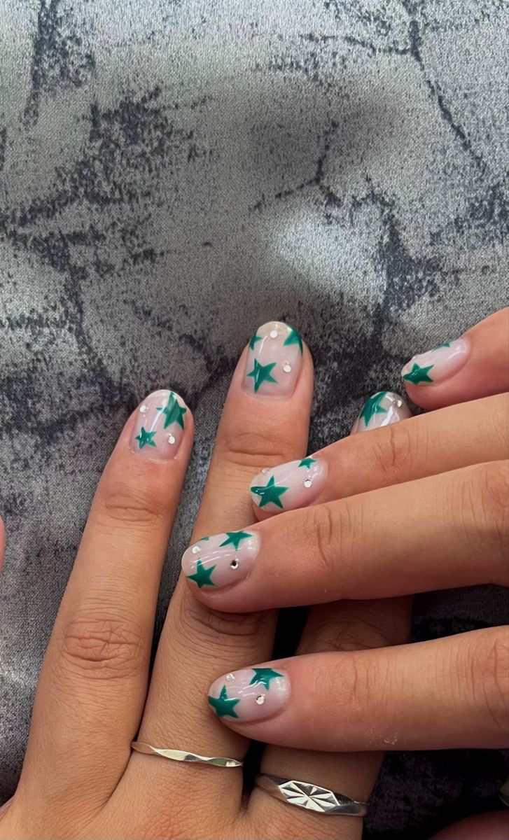 Whimsical Starry Nail Design in Soft Nude with Vibrant Teal Stars and White Accents