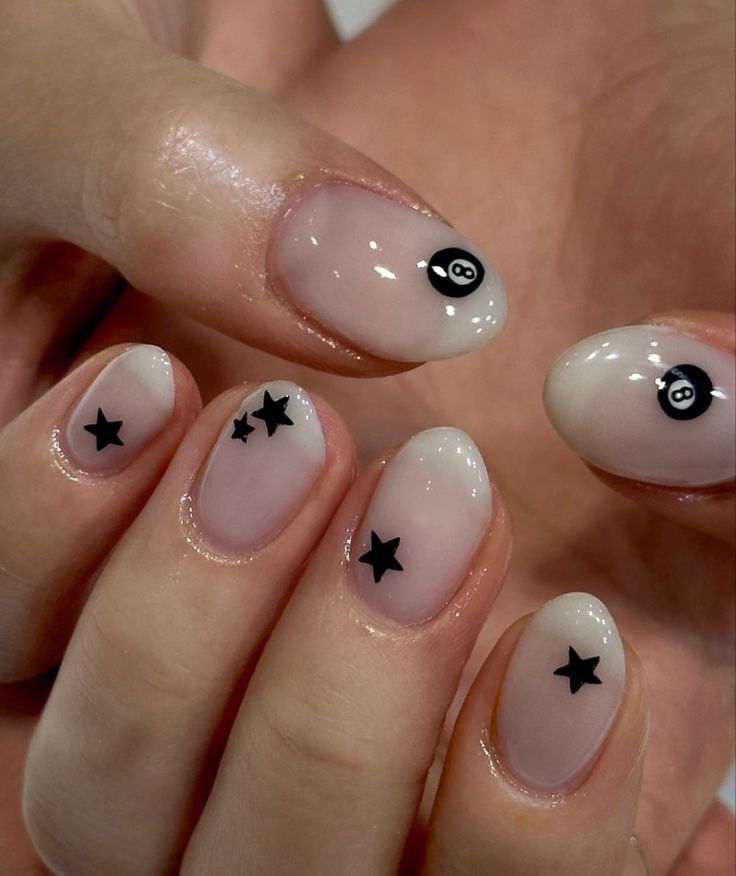 Chic Nude Nail Design with Glossy Finish and Fun Black Star and Billiard Ball Accents.