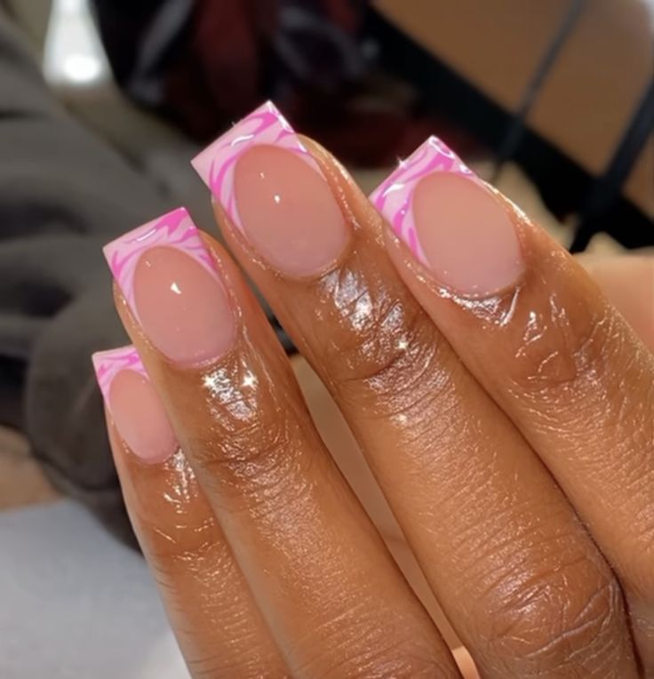 Elegant Nude Acrylic Nails with Vibrant Pink Tips and Artistic Swirls.