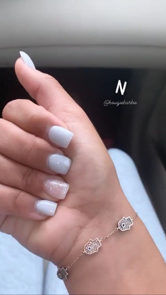 Chic Grey Nail Design with Glitter Accent and Stylish Bracelet.