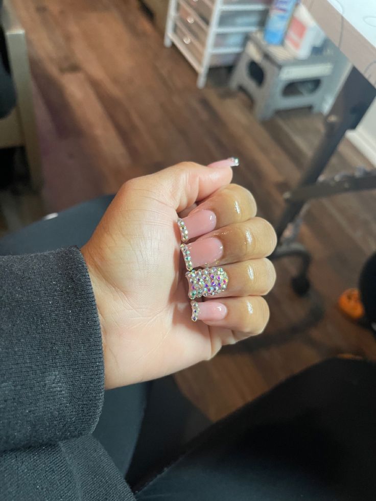 Chic Soft Pink Nail Design with Sparkling Rhinestones and Bracelet Accessory.